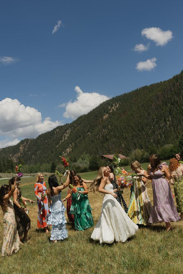 Bride and bridesmaids dancing on the meadow