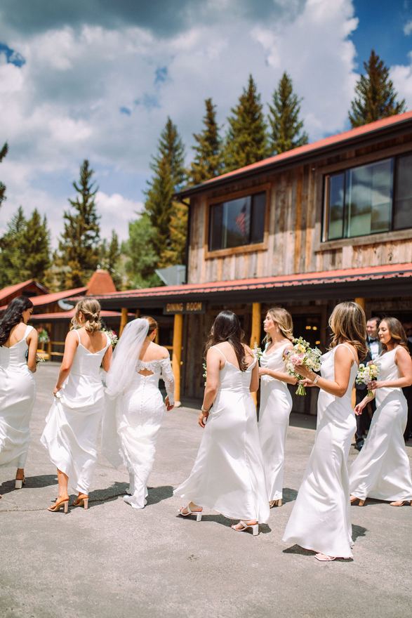 Bride and bridesmaids walking past the lodge