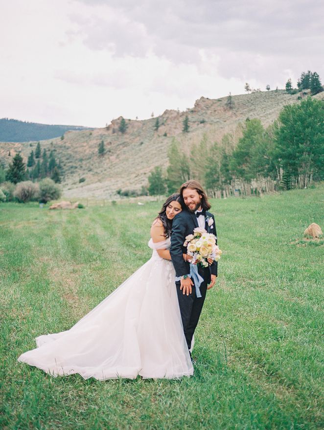 Bride and groom with a bouquet in a meadow
