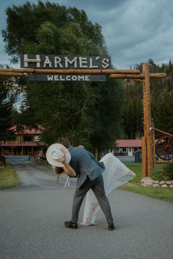 Groom dipping the bride under the Harmel's welcome gate