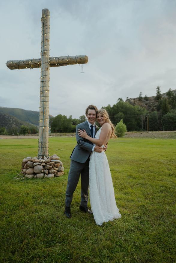 Bride and groom in front of the log cross