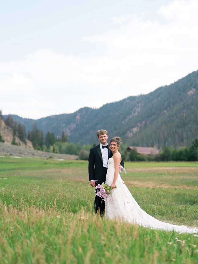 Bride and groom in a mountain meadow