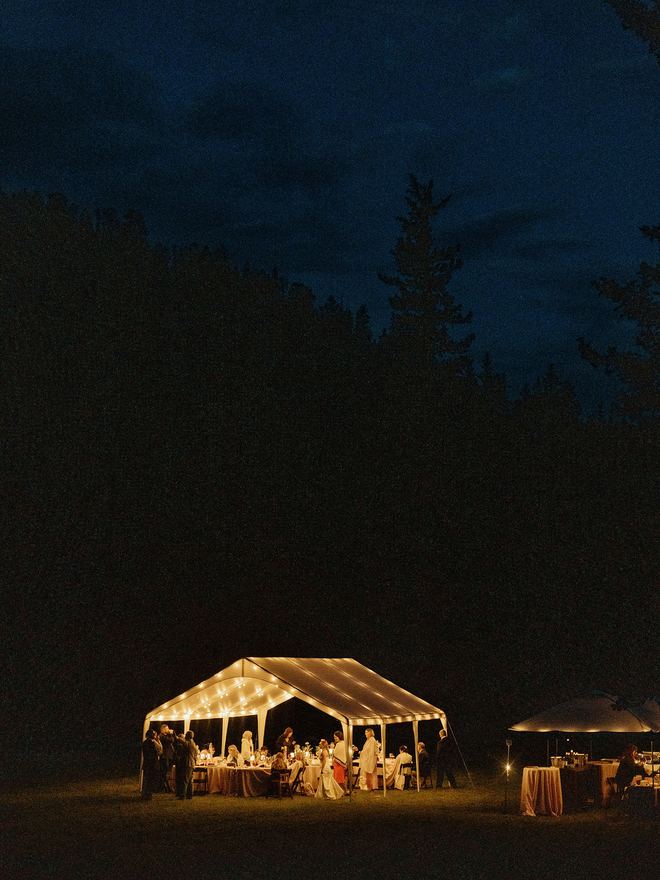 Frame tent glowing at night in the woods