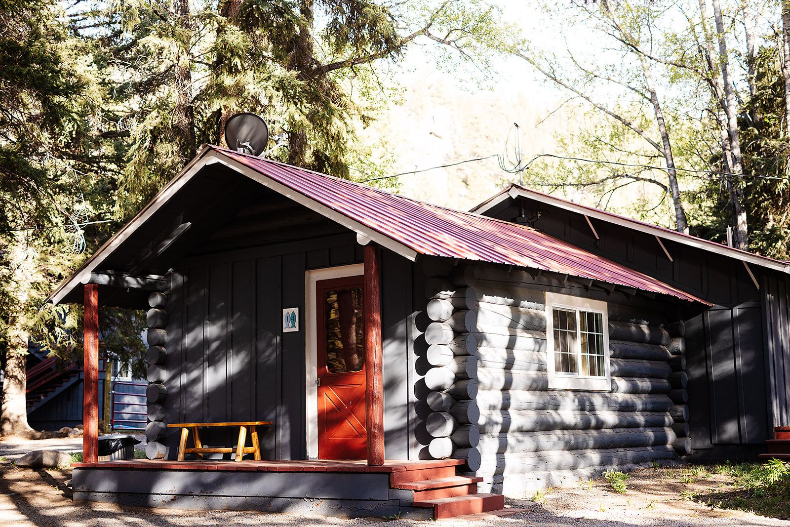 Log cabin with a red door and a picnic table