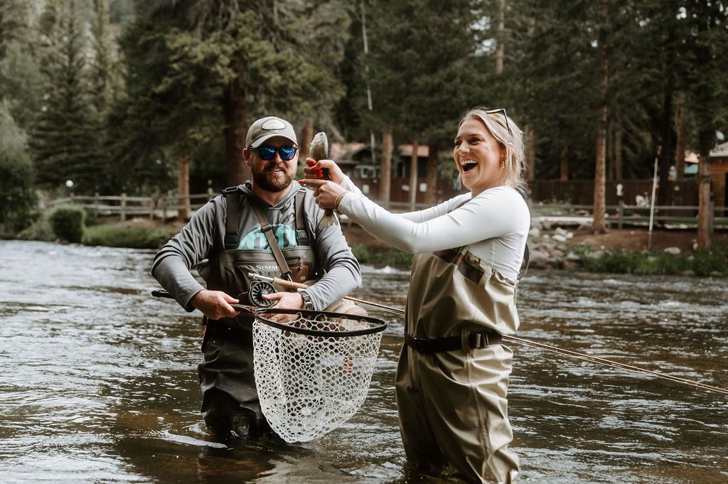 Couple laughing while fly fishing in the Taylor River
