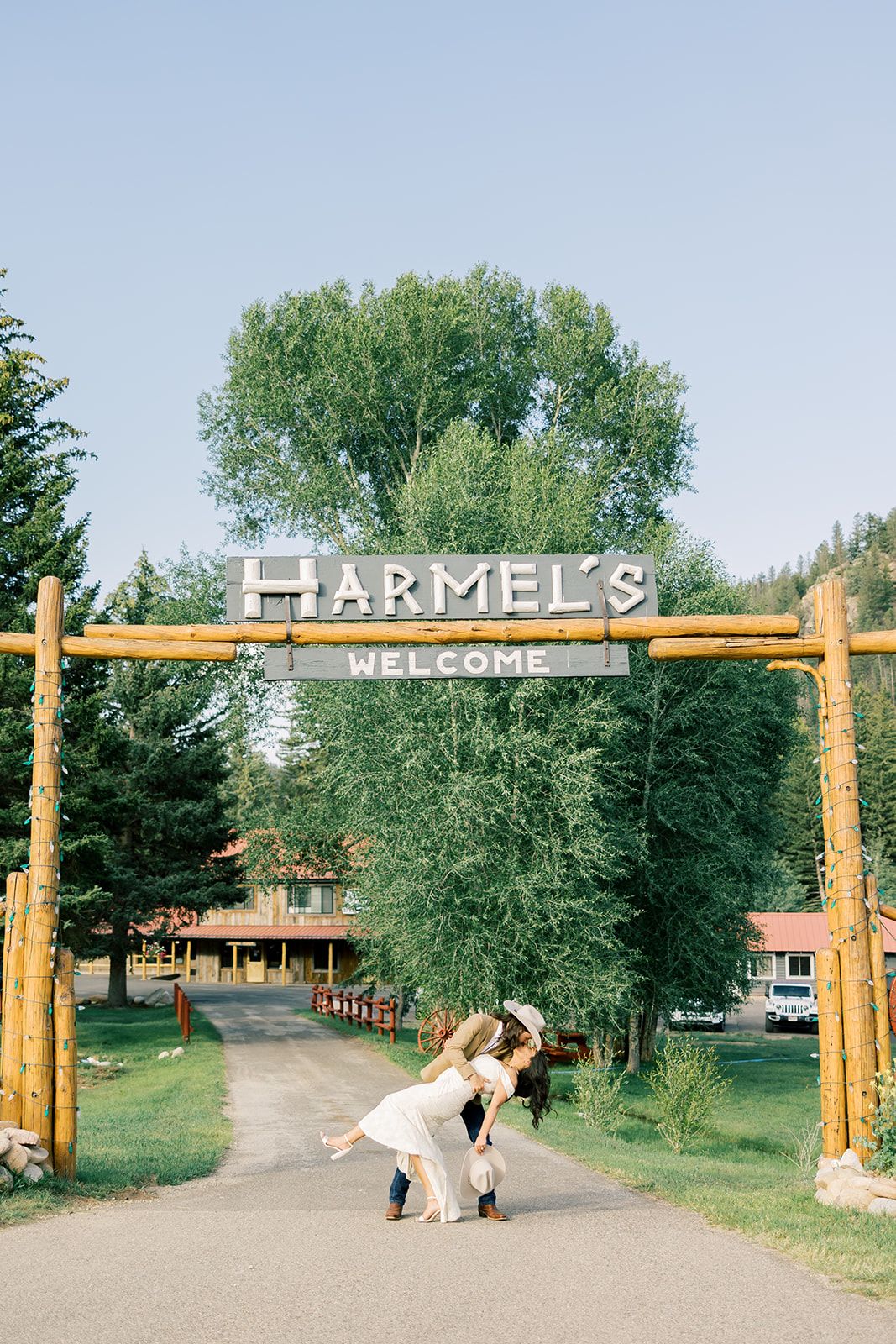 Bride and groom kissing under the Harmel's welcome gate