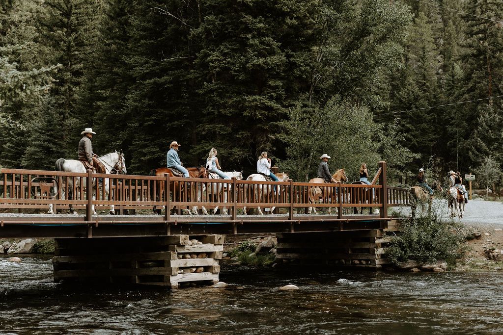 Horseback riders crossing the bridge over the Taylor River
