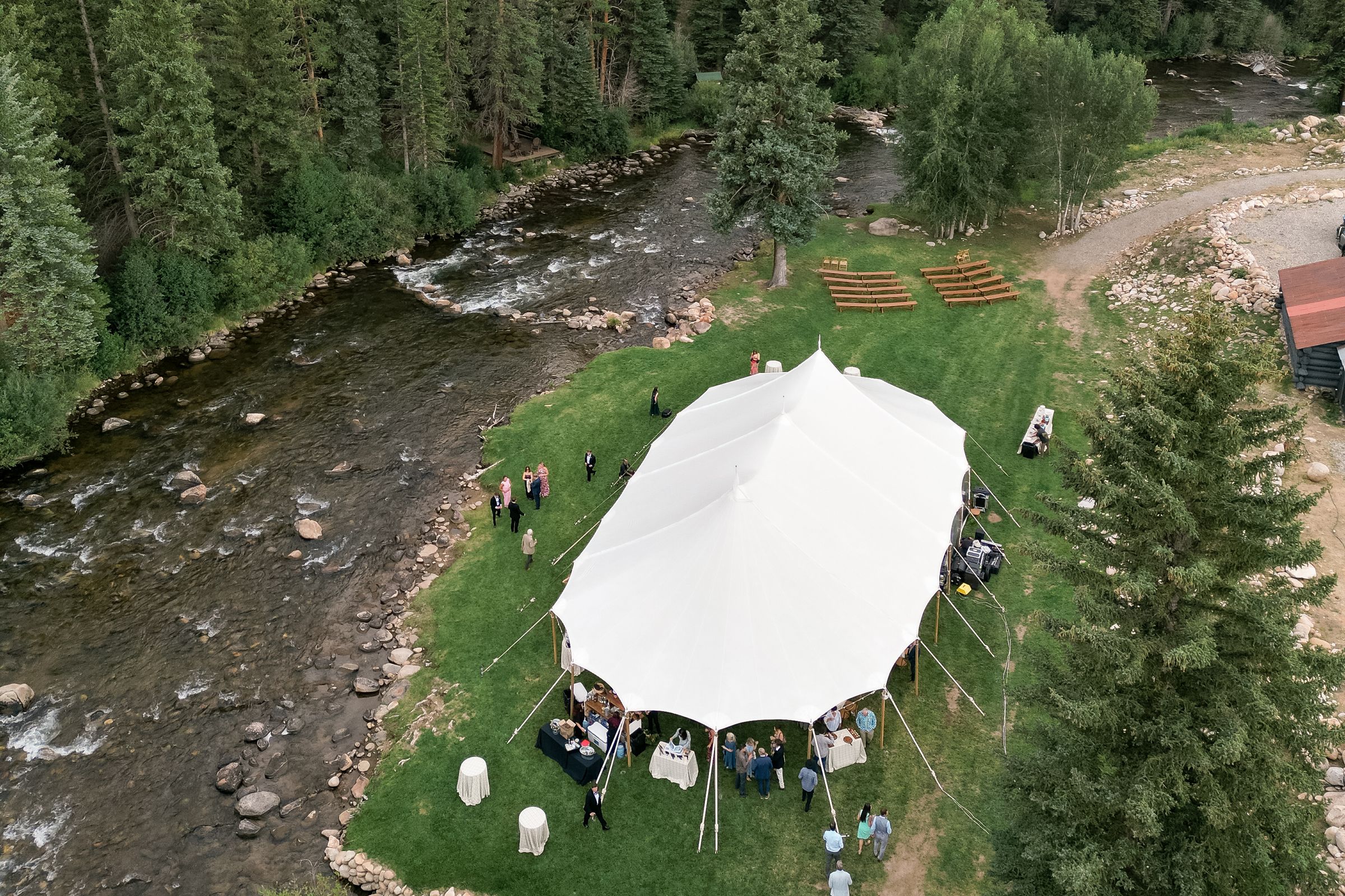 Aerial view of a sailcloth tent and ceremony benches on the Meadow beside the Taylor River